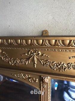 Gilt frame wall hanging mirror flanked each side with small mirrors