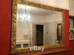 Gold wall mirror with musical instruments around frame